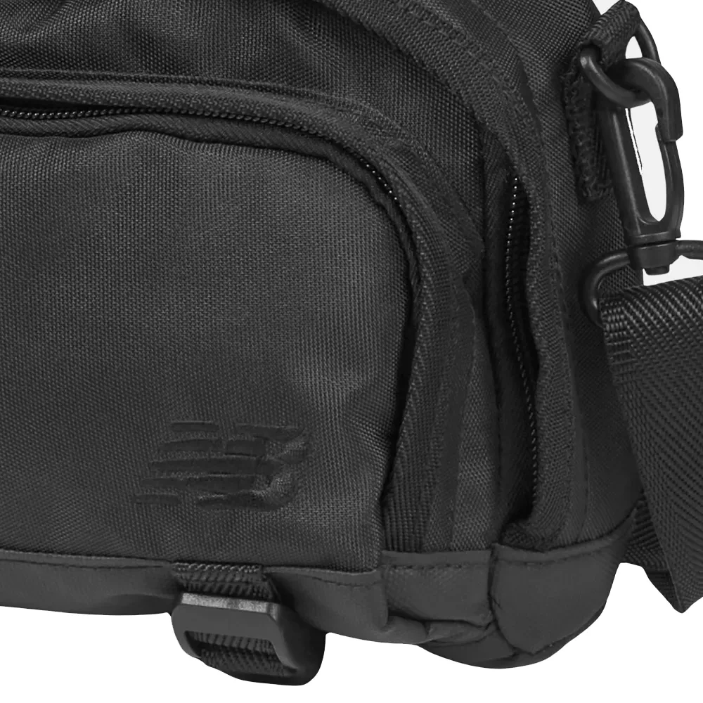 Detalhe da bolsa New Balance preta mostrando tecido resistente e zíper frontal